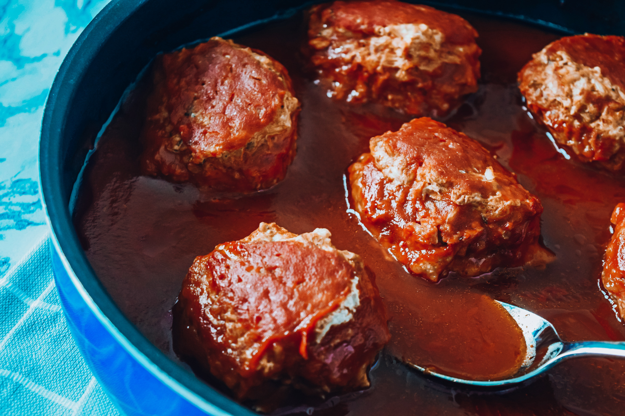 Porcupine meatballs in a skillet with tomato sauce
