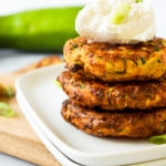 Stack of zucchini fritters on white plate