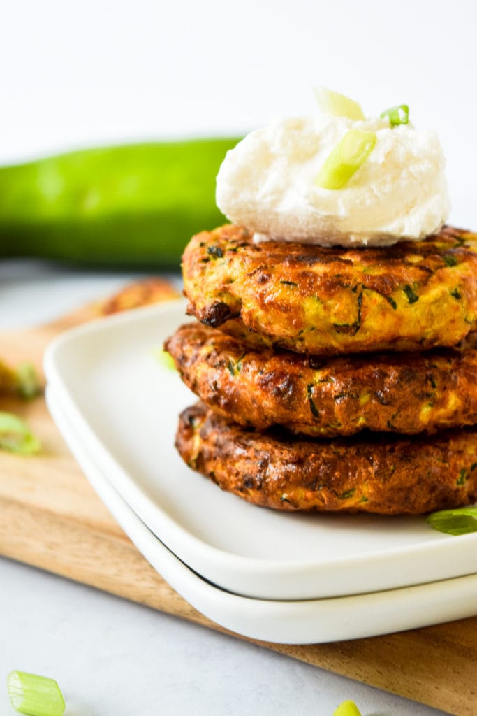 Stack of zucchini fritters on white plate