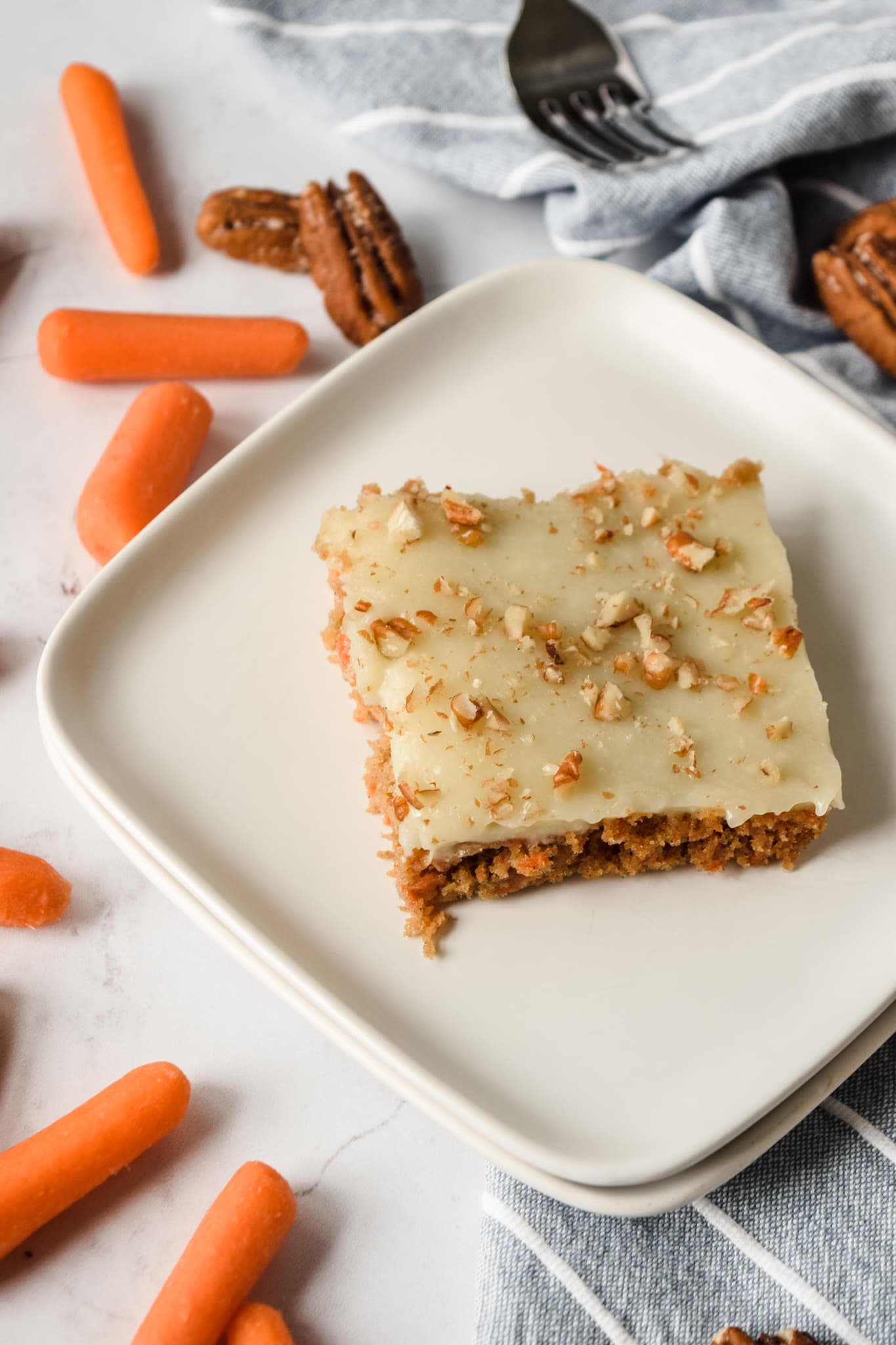 Slice of Gluten Free Carrot Sheet Cake on White Plate with Chopped Pecans