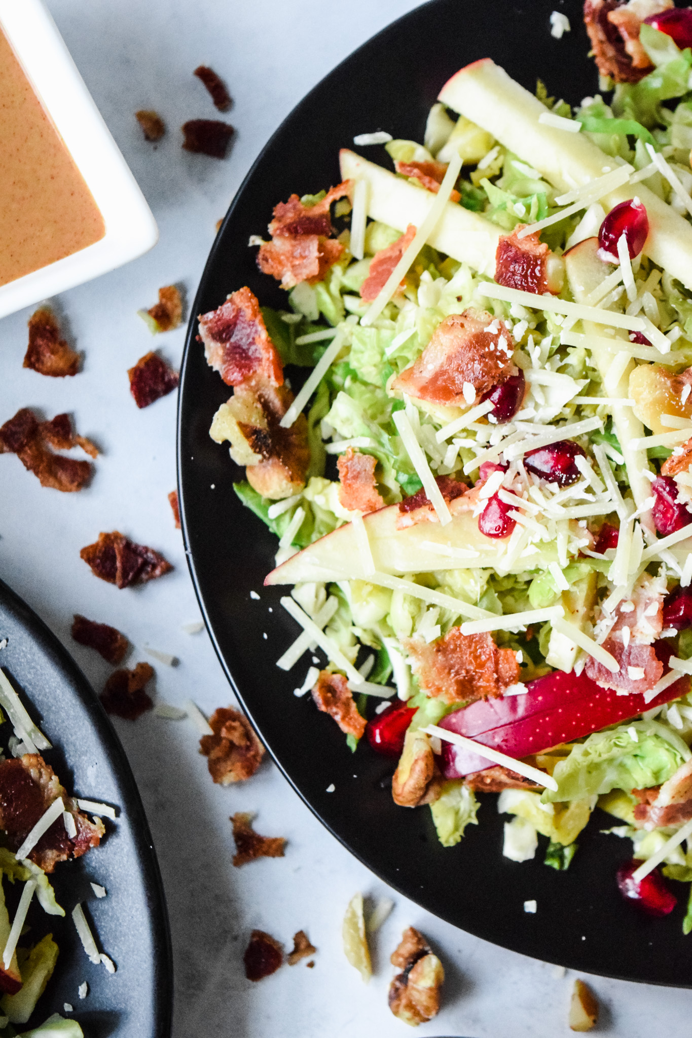 Brussels Sprouts Salad with Apples, Walnuts, Pomegranate Seeds, Bacon, and Grated Parmesan Cheese