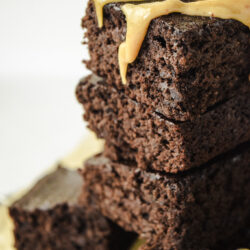 Stack of Gluten Free Black Bean Brownies with a peanut butter drizzle