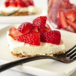 Slice of Gluten Free Strawberry Pretzel Salad on a white plate with a black fork