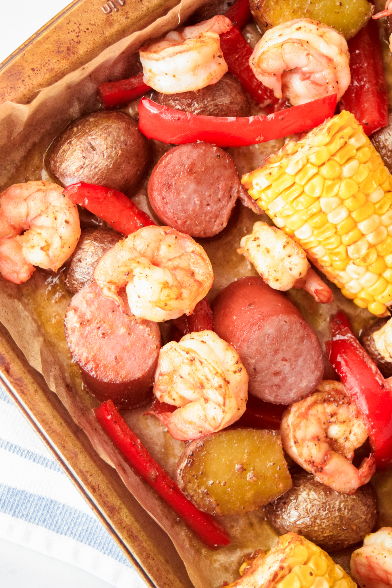 Roasted Shrimp Boil on a Baking Sheet with Corn, Sausage, Potatoes, and Red Peppers