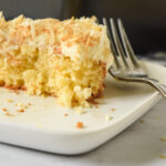 Slice of Gluten Free Pina Colada Cake with Toasted Coconut Flakes