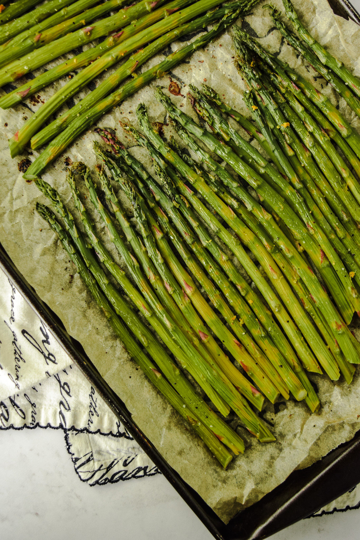 roasted lemon asparagus on a baking sheet with parchment paper
