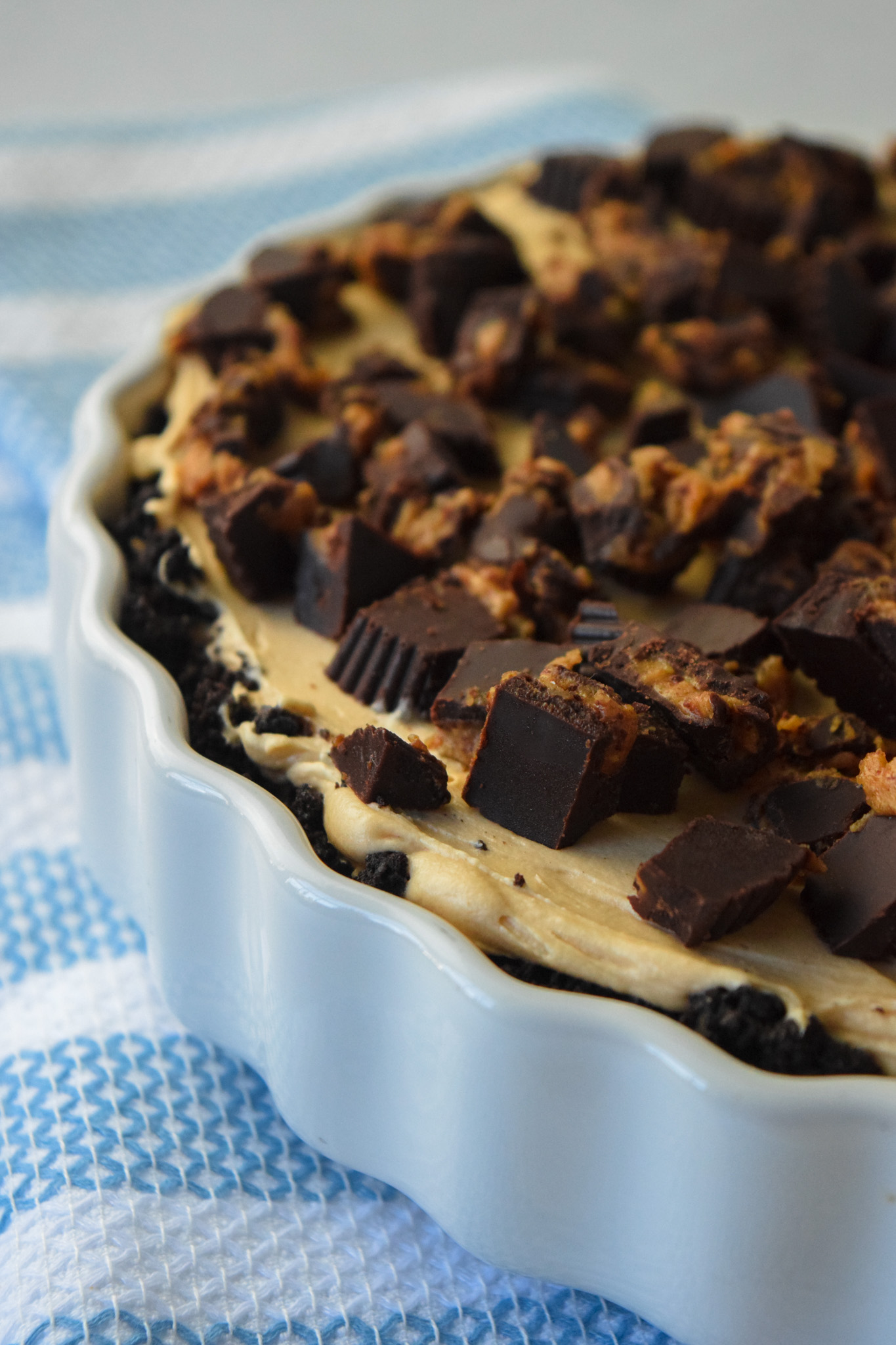 Whole peanut butter pie with a gluten free Oreo crust and chopped peanut butter cups