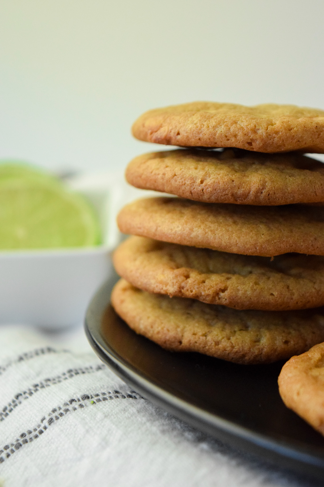 Stack of gluten free key lime cookies on a black plate